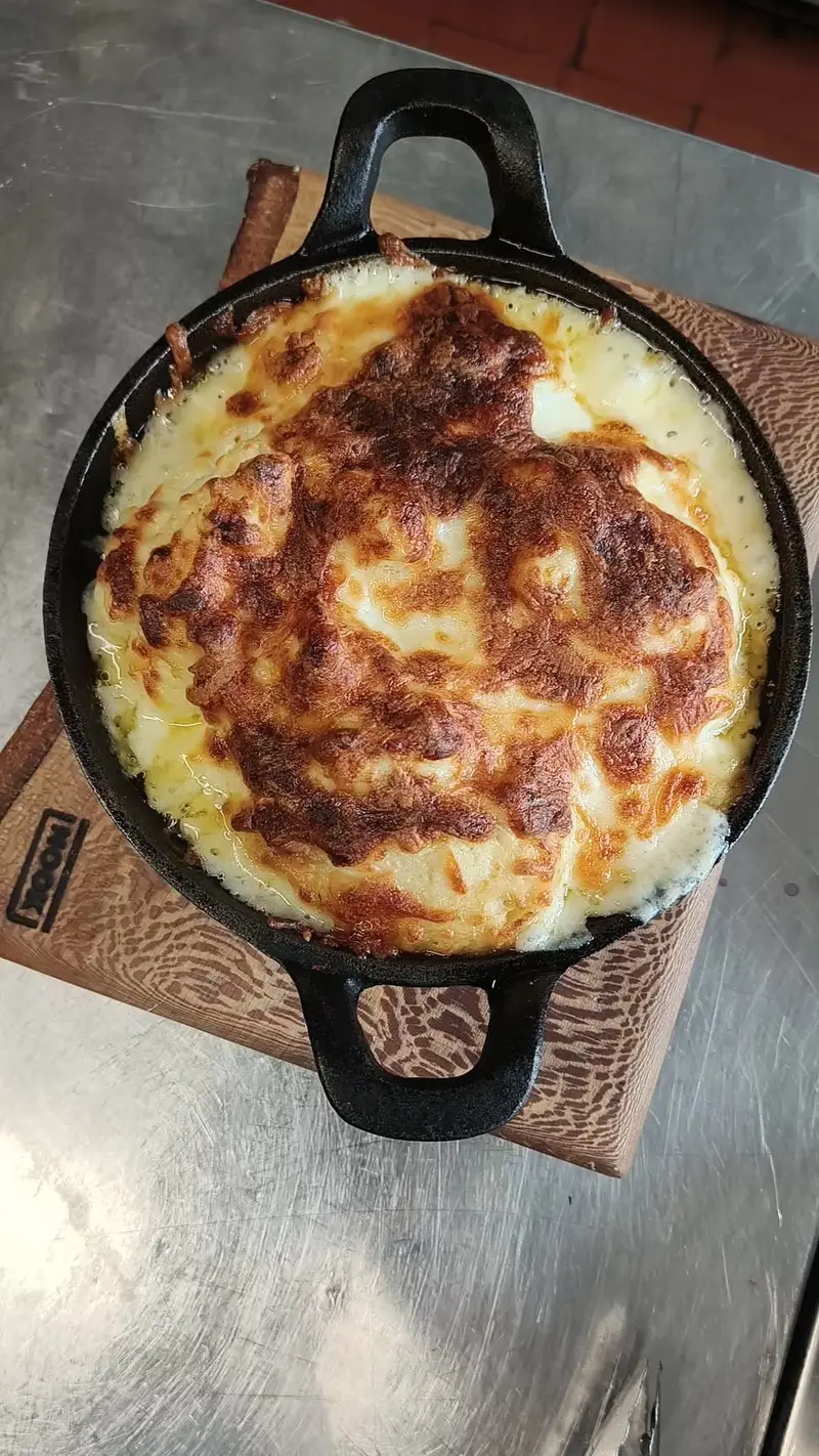 Baked dish in a cast iron skillet on a wooden board.