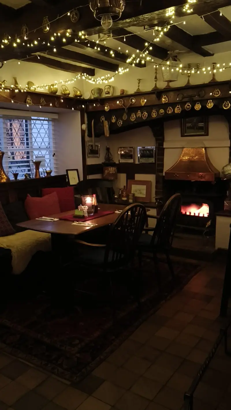 Cozy pub interior with fireplace and decorations.